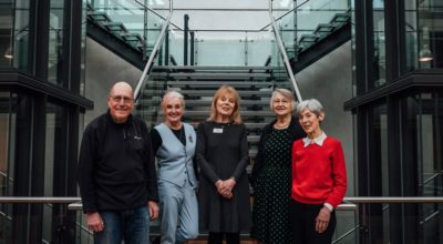 Group image of 5 volunteers stood in front of the glass stairs in the Atrium.